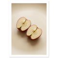 Two red-skinned apple halves with exposed cores on a beige surface, with soft shadows and ample empty space above.