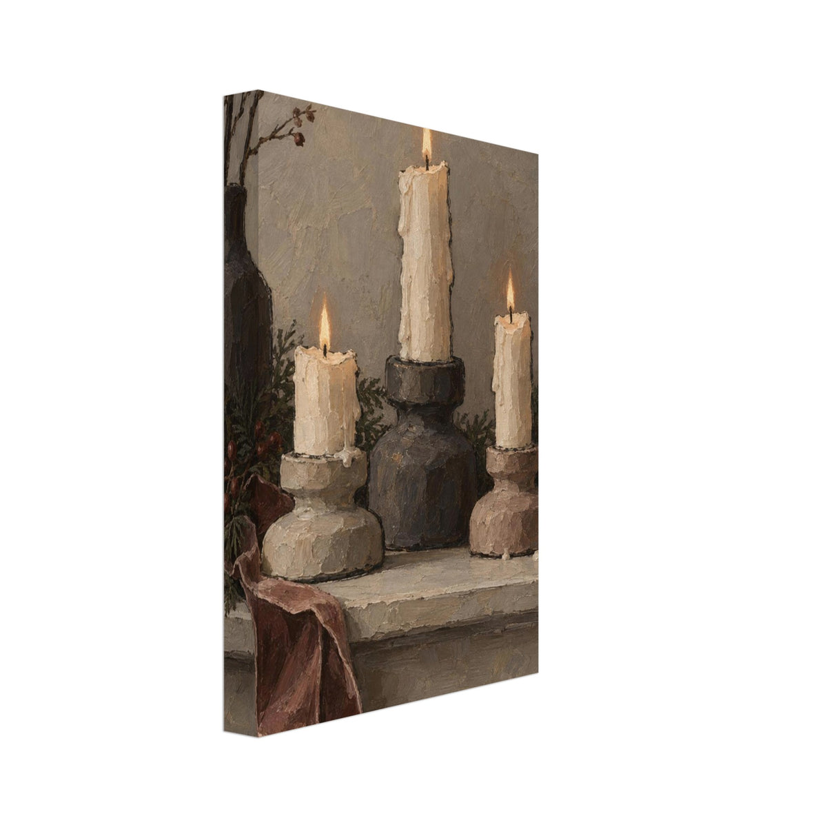 Three lit ivory candles on chunky holders, with a dark vase, branches, greenery and a draped burgundy ribbon.