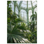 Lush palm fronds beneath tall arched windows and an ornate, pale green metal and glass roof in a sunlit glasshouse.