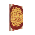 Golden pasta ribbons on a deep red plate, viewed from above against textured red and cream vertical stripes.