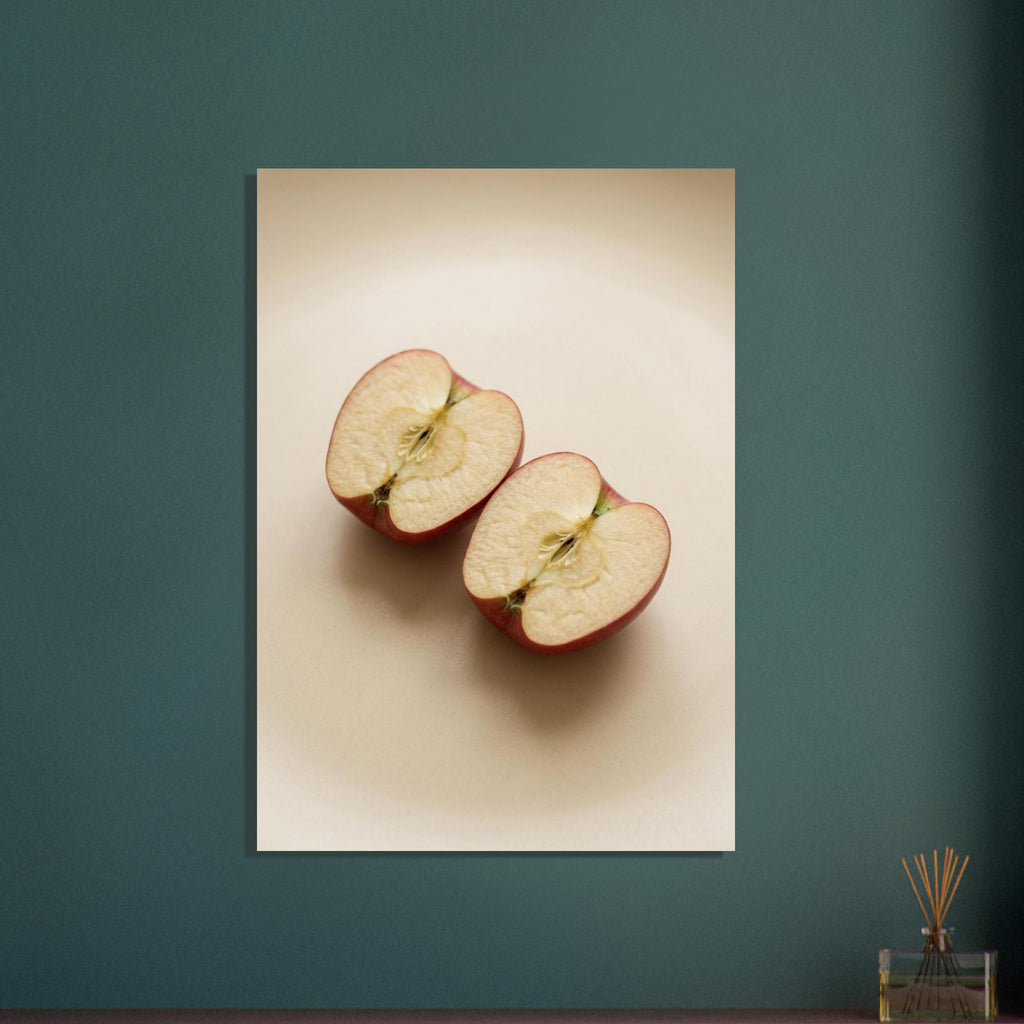 Two red-skinned apple halves with exposed cores on a beige surface, with soft shadows and ample empty space above.