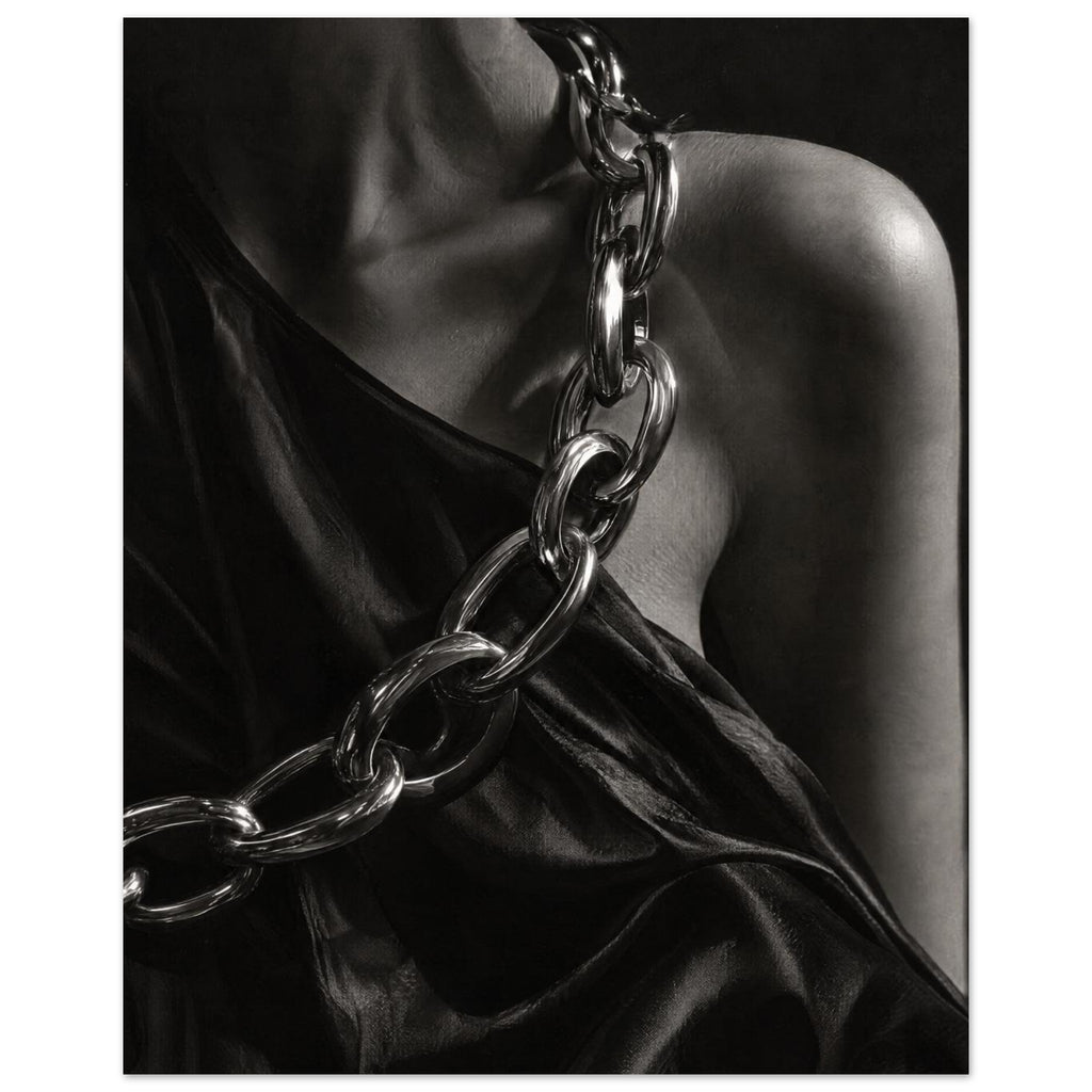 Oversized polished chain links cross dark, lustrous fabric beside a bare shoulder and neckline in black and white.