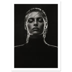 Black and white portrait of a woman with closed eyes, slicked-back hair and a dark high-neck top against black.