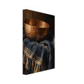 Hammered copper bowl on folded indigo cloth with cream stripes and tassels, painted against a dark brown background.
