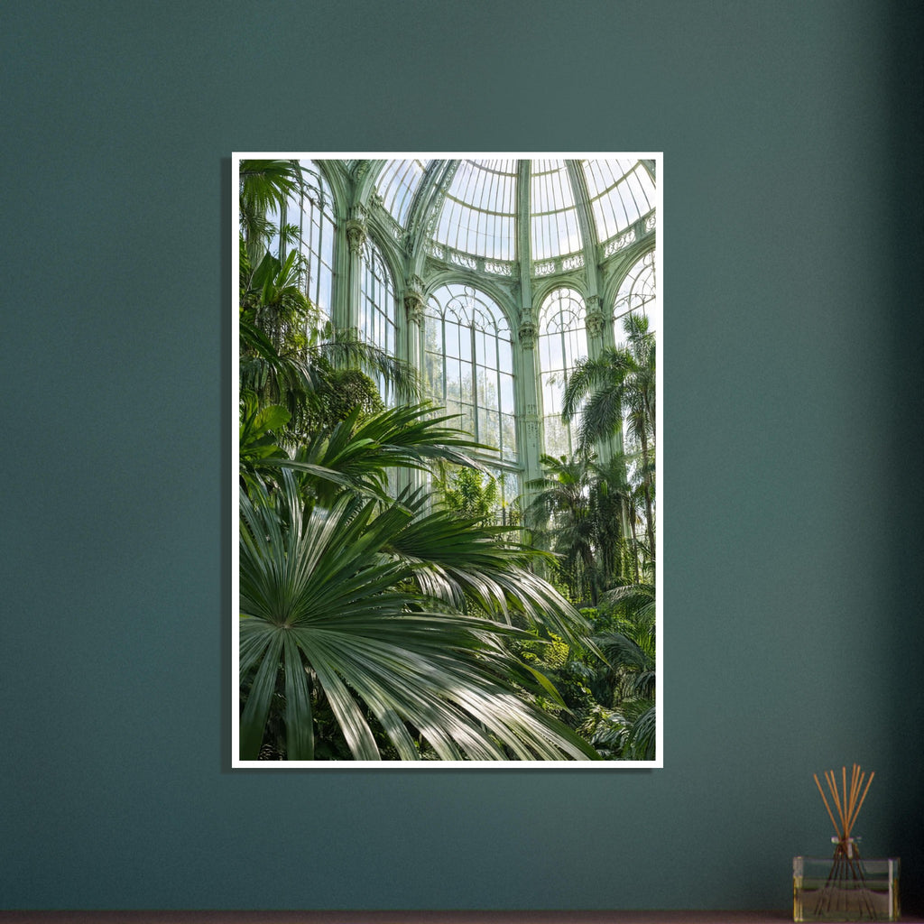Lush palm fronds beneath tall arched windows and an ornate, pale green metal and glass roof in a sunlit glasshouse.