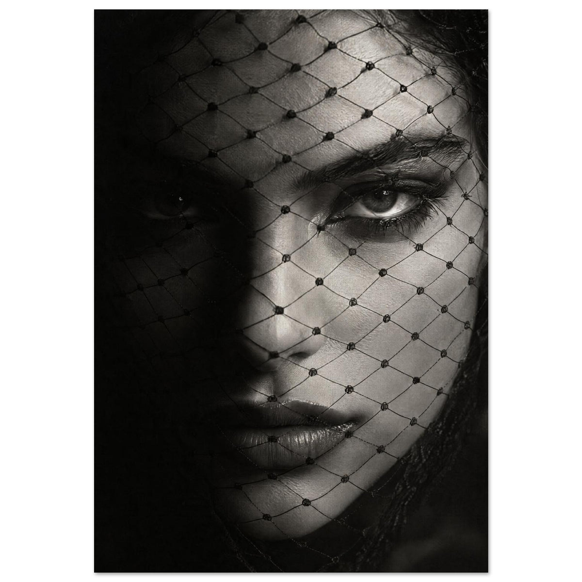 Woman's face behind a diamond-patterned net veil, with one eye brightly lit and the other in deep shadow, in black and white.