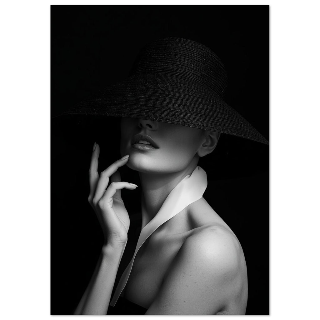 Woman in a wide-brim black hat hiding her eyes, with a hand near her chin and a white collar, in black and white.