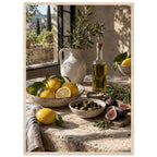 Lemons, olives, figs and a bottle of oil on a stone table beside a ceramic jug of leafy branches and a sunlit window.