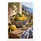 Lemons in a blue-and-cream ceramic bowl on a rustic table, with olive branches, checked cloth and a coastal view.