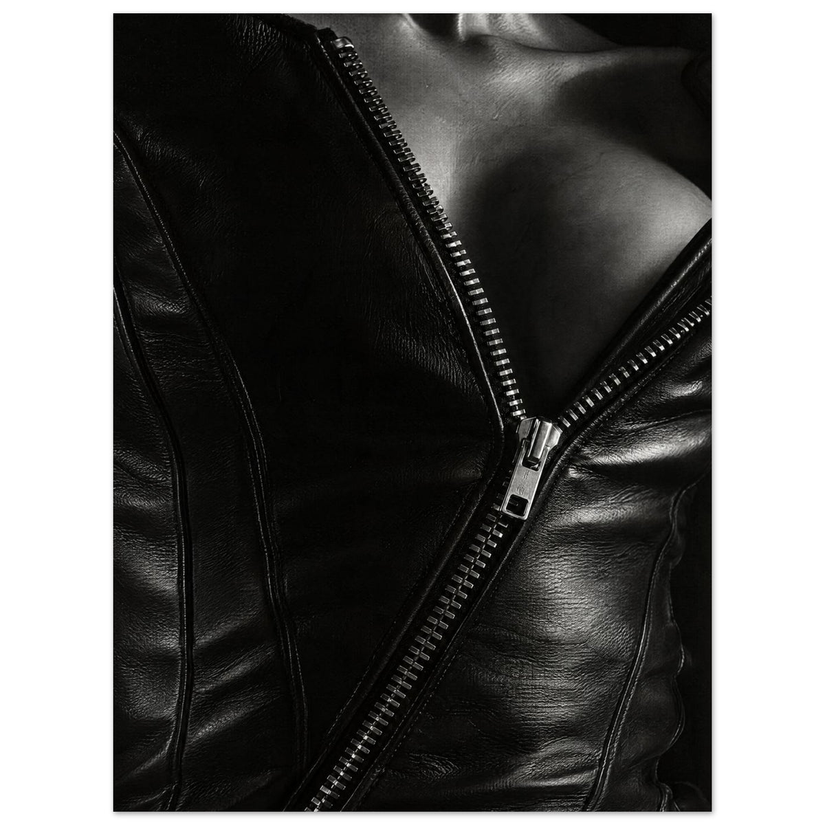 Black and white close-up of an open leather jacket with a diagonal metal zip and an exposed neckline.