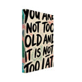 Bold black text reading “You are not too old and it is not too late” on cream with colourful brush marks and loops.