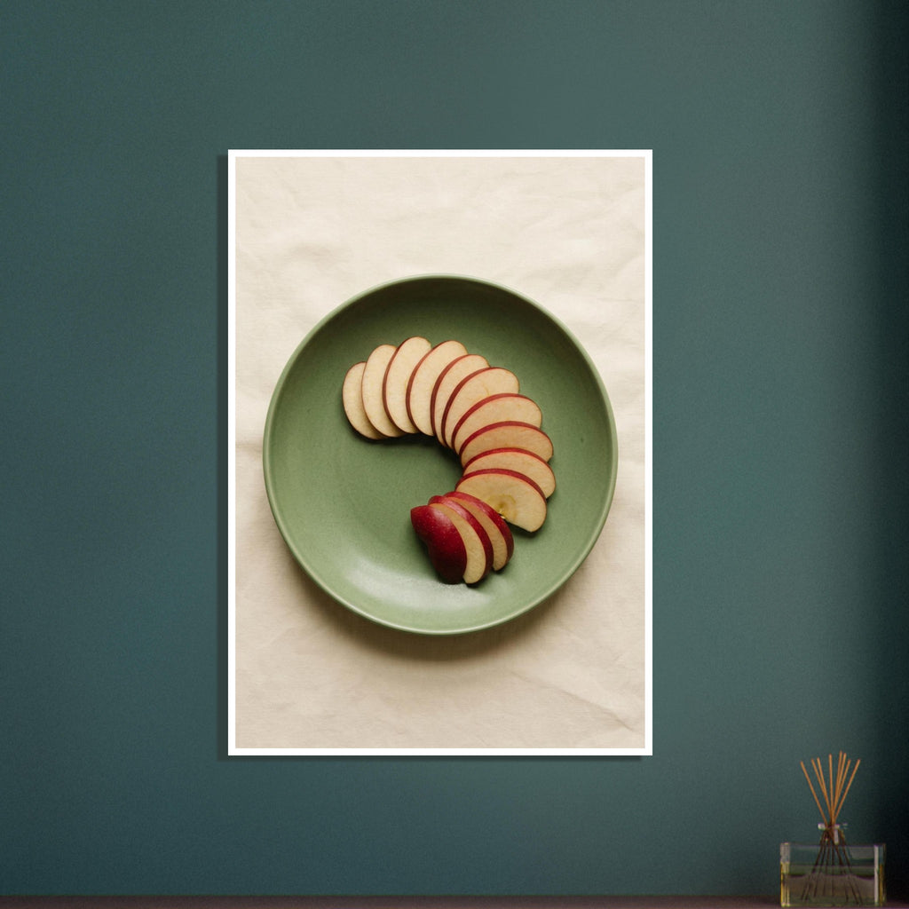 Red-skinned apple slices arranged in a curve on a green plate, photographed from above on cream fabric.