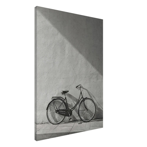 Bicycle leaning against a textured wall, with diagonal sunlight and long shadows across the wall and pavement.