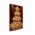 Champagne cascading down a tower of coupe glasses, lit by warm spotlights against deep burgundy curtains.