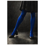 Cobalt Stockings, cropped legs in blue tights and black shoes forming an angular pose against a charcoal studio background.