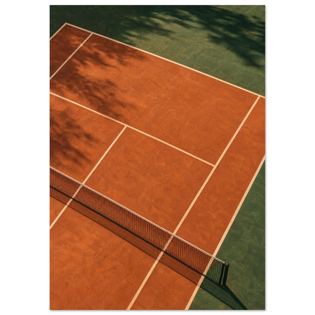 Terracotta tennis court viewed from above, with green surrounds, pale lines, a dark net and tree shadows.