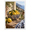 Lemons in a blue-and-white bowl on a wooden table, with olive branches, checked cloth and a coastal village beyond.