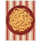 Golden pasta ribbons on a deep red plate, viewed from above against textured red and cream vertical stripes.
