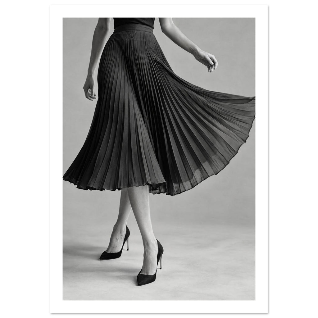 Cropped figure in a flowing black pleated skirt and pointed high heels, with crossed legs against a grey background.