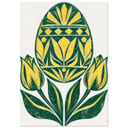 Yellow and green patterned Easter egg above two yellow tulips and sweeping green leaves on a cream background.