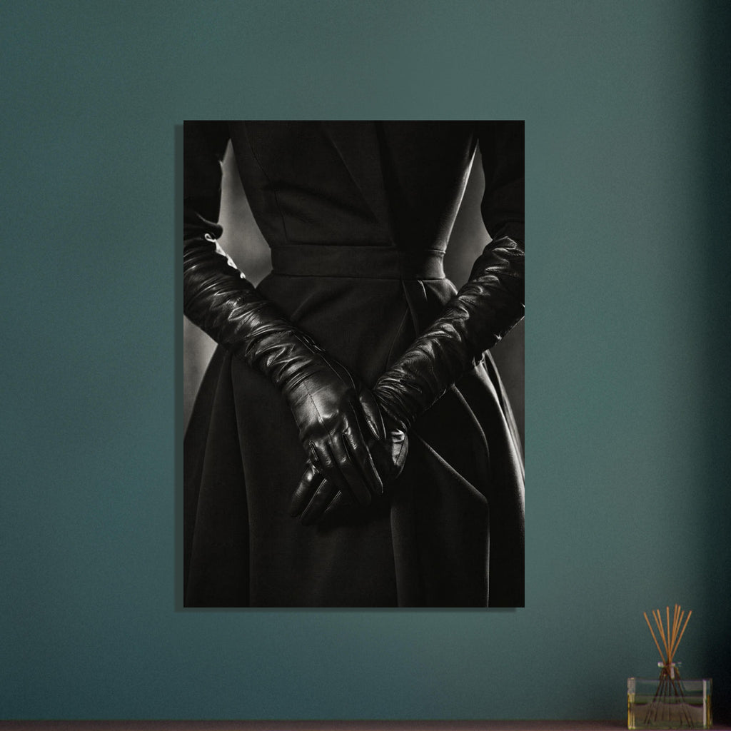 Overlapping hands in long black leather gloves against a dark fitted outfit, photographed in black and white.