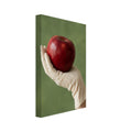 Red apple resting in a cream-gloved hand, with a bare forearm below and a softly blurred green background.