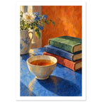 Bowl of tea beside stacked books and a jug of white and blue flowers on a blue table against an orange background.