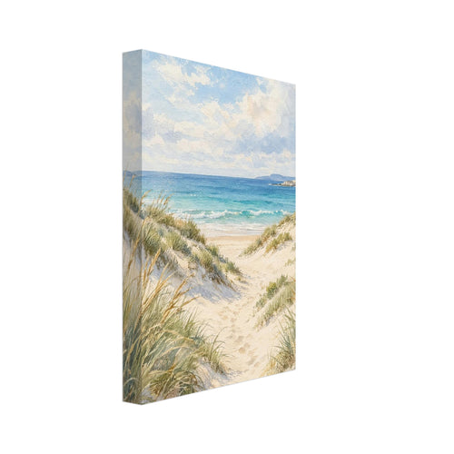 Sand dunes with grasses and footprints leading to turquoise waves beneath a blue sky with soft white clouds.
