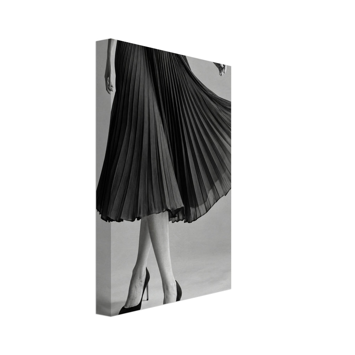 Cropped figure in a flowing black pleated skirt and pointed high heels, with crossed legs against a grey background.