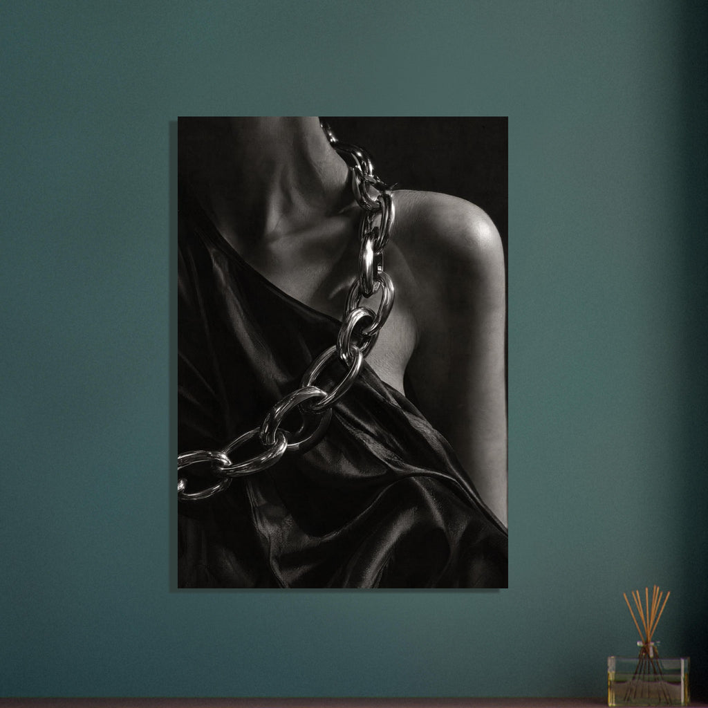 Oversized polished chain links cross dark, lustrous fabric beside a bare shoulder and neckline in black and white.