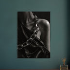 Oversized polished chain links cross dark, lustrous fabric beside a bare shoulder and neckline in black and white.